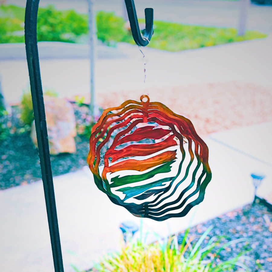 Outdoor spinner on a hook that spins. Colorful with flag shapes, pride flag colors for LGBT