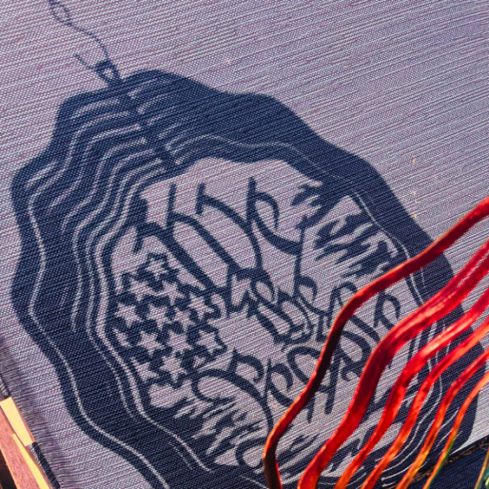 a shadow of a wind spinner that says "we the people" and has a tattered flag and stars outlined 