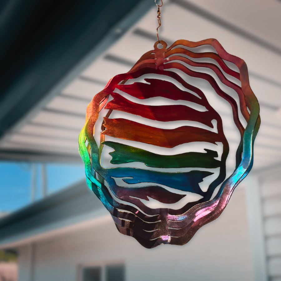 LGBTQ+ representation, with colors that are supportive of pride month. Wind spinner hanging by a hook from a deck overhang 